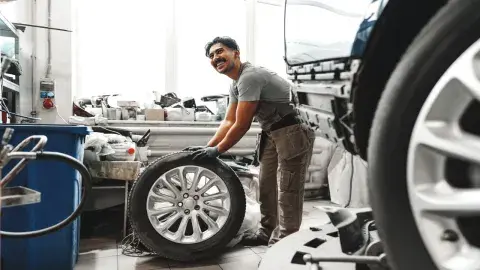 man holding car tyre